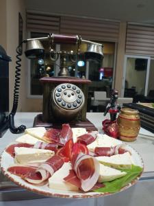 普卢日内Guesthouse Eko Piva的一张桌子上一盘肉和奶酪,配有电话
