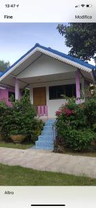春蓬The Mountain View Hat Sai Ri Resort的一座房子,有粉红色的门和一些灌木丛