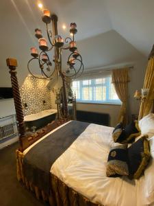 WoodmancoteVarr House @ Meadow View的一间卧室配有一张带吊灯的大床