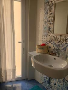 马里迪莫Camera matrimoniale LA LAMPUGA的浴室设有白色水槽和镜子