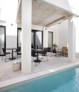 瓦伦西亚YOURS boutique stay的一个带桌椅的户外庭院和一个游泳池