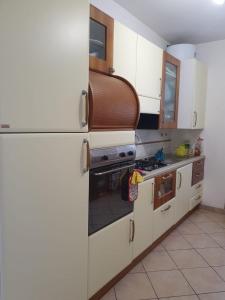 TossiciaFlamignano: un paradiso nel verde的厨房配有白色橱柜和炉灶烤箱。