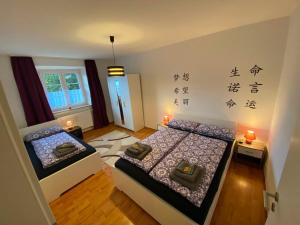 奥格斯堡Ferienwohnung Augsburg 1的墙上写有亚洲文字的房间里,有两张床