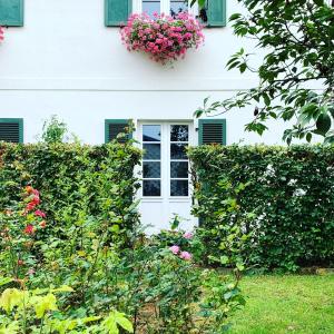BeckerichIsabelle's Rosegarden的白色的房子,有窗户和鲜花