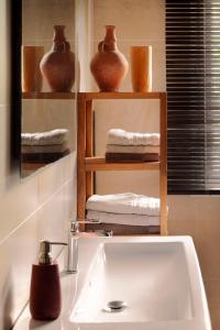 PanazolMerveilleuses chambres d'hôtes à Panazol的浴室设有水槽和带毛巾的架子。