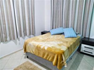 弗洛里亚诺波利斯Pousada Souza的一间卧室配有一张带黄色床单和蓝色枕头的床。