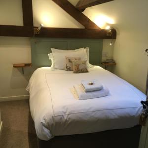 Monk FrystonThe Barn的卧室配有一张带白色床单和枕头的大床。