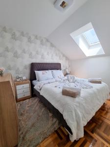 索科矿泉村AS Delux Apartmani的一间卧室配有一张带天窗的大床