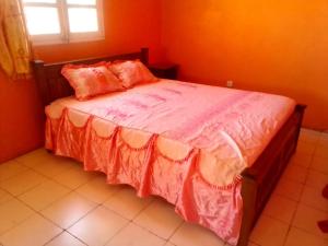 图利亚拉TULEAR APPARTEMENTS CHAMBRES VILLAs的一间卧室配有一张带橙色墙壁和窗户的床
