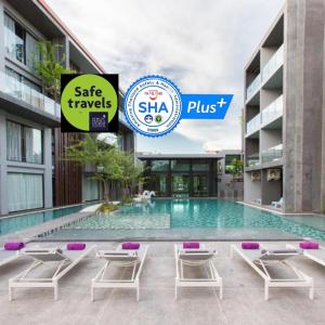 奈扬海滩Maya Phuket Airport Hotel - SHA Extra Plus的一座大楼前的游泳池,配有躺椅