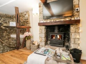 马姆斯伯里Corner Cottage的客厅设有石制壁炉和电视。