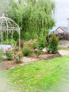 BeckerichIsabelle's Rosegarden的花园设有白色凉亭和鲜花