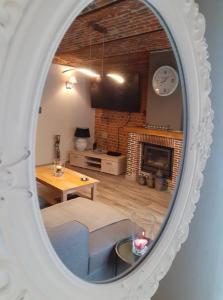 图尔奈乐千恩吉特度假屋的镜子反射着带壁炉的客厅