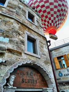 格雷梅Zeus Cave Suites的上面有热气球的砖砌建筑