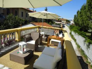 比萨比萨斜塔旅馆的阳台的天井配有椅子和遮阳伞。