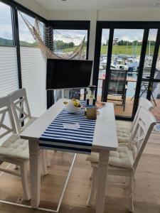BraunsbedraHausboot Casa di Lago的白色的桌椅,享有船只的景色