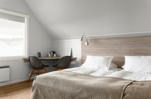 维克Vík Cottages的一间卧室配有一张床、两把椅子和一张书桌