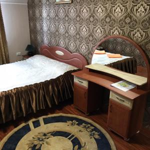 Zhensna PolʼskaІдилія的一间卧室配有一张床、一张桌子和一张地毯。