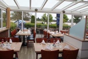 布雷格Hotel & Restaurant Am Wasser的餐厅设有桌椅和窗户。
