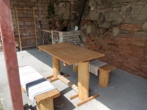 CserháthalápNagyhaláp的砖墙前的木餐桌和长凳