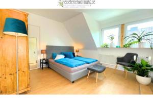 瓦尔斯罗德heideferienwohnung - die neue Ferienwohnung的一间卧室配有蓝色的床和椅子