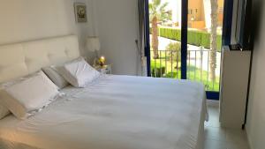 卡布罗伊格Cabo Roig - Blue Luxury Apartment的带阳台的卧室内的一张白色床