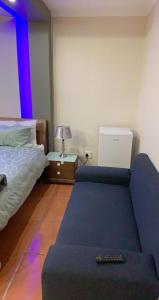 SandtonMade Guest House的一间卧室配有一张床和一张带遥控器的沙发。