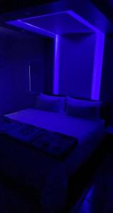 SandtonMade Guest House的一间卧室配有一张蓝色的灯光床
