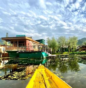 斯利那加Green Paradise Houseboat - Centrally Heated的建筑物前水面上的黄色船