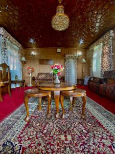 斯利那加Green Paradise Houseboat - Centrally Heated的客厅配有桌子和沙发