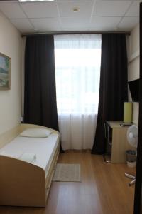 巴尔瑙尔Гостиница Бизнес Турист的一间卧室设有一张床和一个大窗户