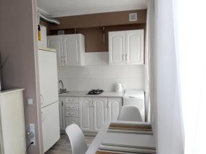 切尔尼戈夫1ком БЕЛАЯ МЕЧТА Центр ЦУМ посуточно почасово месяц的小厨房配有白色橱柜和白色椅子