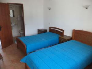 Barão de São JoãoCasa do João的配有蓝色床单的客房内的两张床