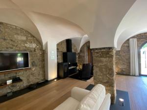 圣霍安-莱斯丰特斯Casa Rural el Serrat de Baix的客厅配有沙发和石墙电视。