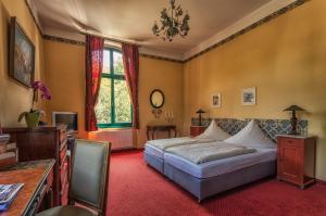萨勒河畔瑙姆堡楚亨酒店的一间卧室配有一张床、一张书桌和一个窗户。