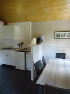 CarentoirLe Domaine du Cerf Blanc的厨房配有木桌、椅子、桌子和桌子。