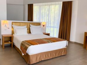 阿尔沃尔Foz Club - Algarve的一间卧室设有一张大床和大窗户
