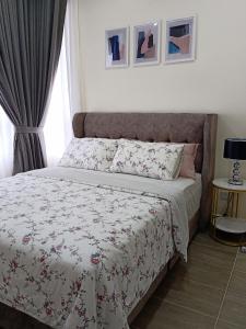 哥打巴鲁Al Zahra Homestay by Troika Kota Bharu的一间卧室配有一张带花卉床罩的床