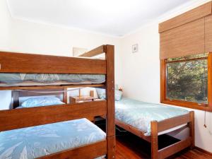 霍克斯内斯特Gumtree Cottage Hawks Nest的一间卧室设有两张双层床和一扇窗户。