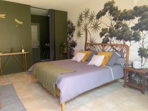 沙伯伊Chambre en Drôme Tropicale的一间卧室配有一张大床和枕头