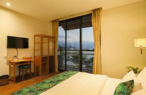 纳闽巴霍生态树奥特尔酒店的配有一张床、一张书桌和一扇窗户的酒店客房