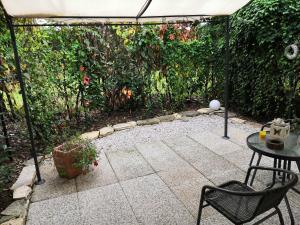 维琴察Country Home B&B Il Melo的一个带桌子和遮阳伞的庭院