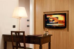 格罗塔费拉塔葛拉索利公园别墅酒店的一张桌子、椅子和墙上的电视