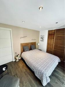 GuichenLe Boulay的一间卧室配有一张大床和木制床头板