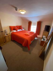 LlanfyllinOld New Inn, Llanfyllin的一间卧室配有一张带橙色床罩的床