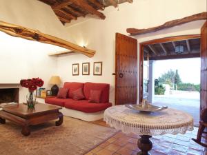伊维萨镇马里亚诺旅馆的客厅配有红色的沙发和桌子