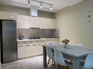 博尔若米nikani的厨房配有桌椅和冰箱。