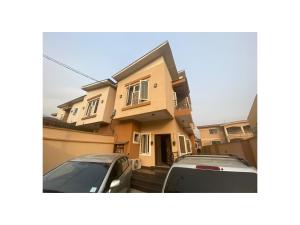 伊凯贾Amazing 4 Bedroom Duplex in Ikeja Allen Avenue的两辆汽车停在房子前面的房子