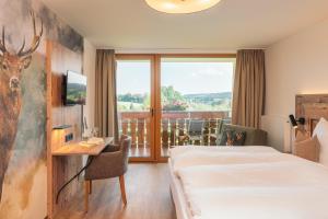 弗罗伊登施塔特兰得佳斯毫斯索尼酒店的配有一张床、一张书桌和一扇窗户的酒店客房