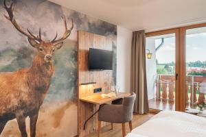 弗罗伊登施塔特兰得佳斯毫斯索尼酒店的卧室墙上挂着鹿画